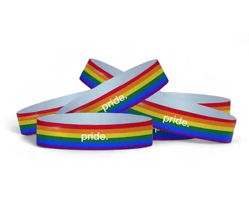 um grupo de pulseiras Tyvek personalizadas com as cores do orgulho, com a palavra pride escrita nelas